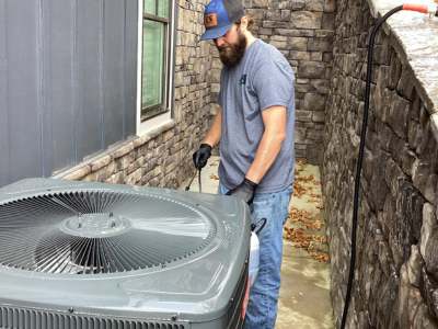 Engle Services HVAC technician servicing an outdoor AC unit at a Birmingham, AL home